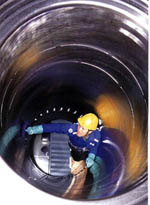 A Sulzer worker stands inside a cylinder liner for a slow speed two stroke engine